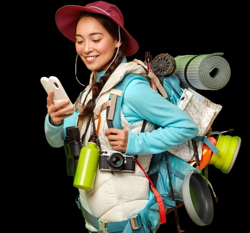 Smiling traveler with a hiking backpack checking her phone before an international trip
